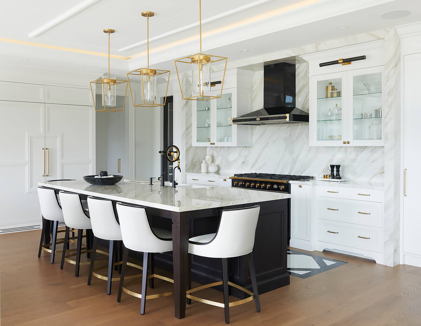 kitchen island with 5 white modern stools and 3 pendant lights